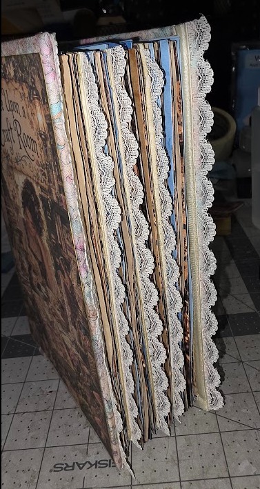 Side view of a handmade journal showing layered pages and lace trim